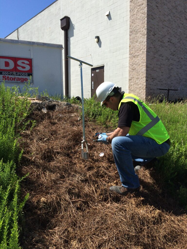 A Geo-Hydro team member sampling soil at a project site.